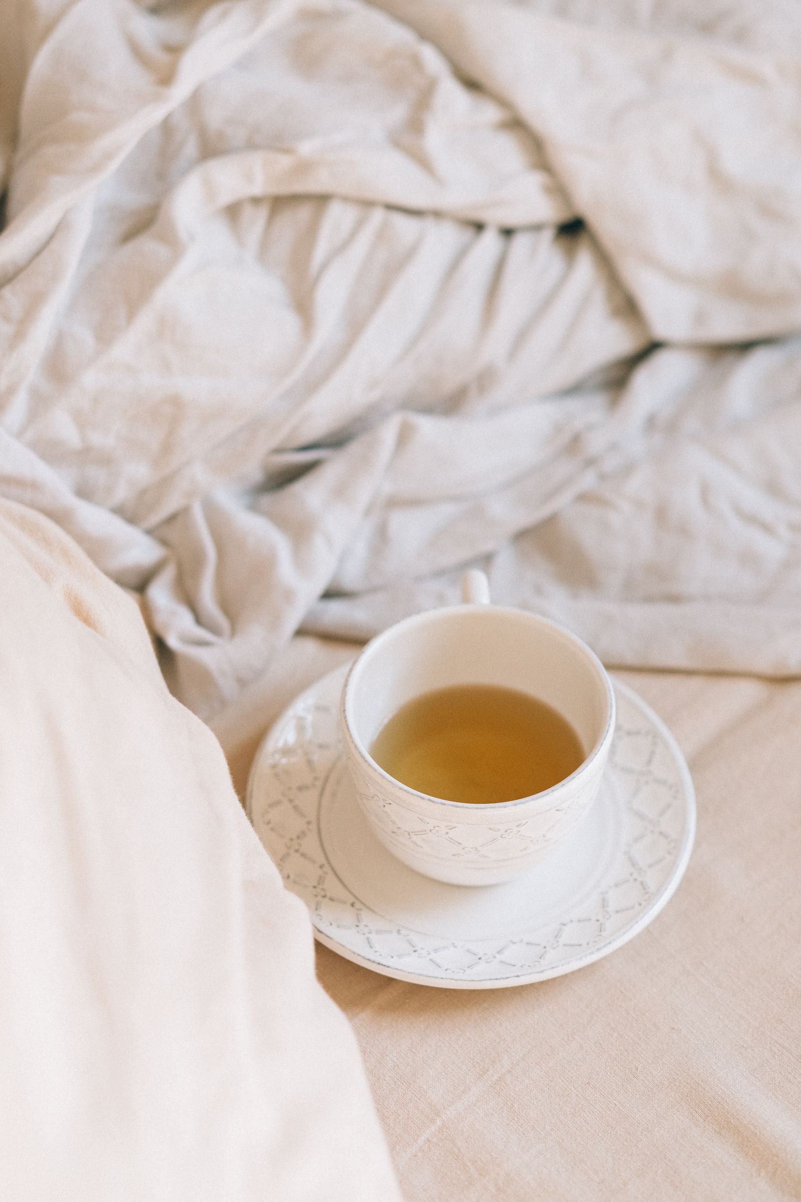 A cup of herbal tea on soft, neutral linen